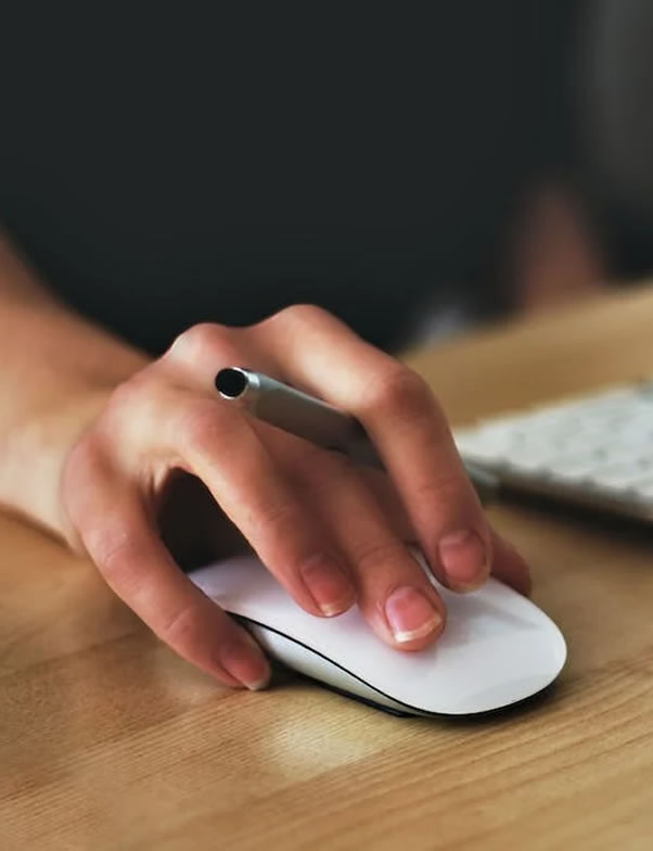 laptop and a hand holding a mouse